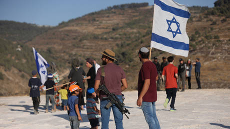  Israeli settlers gather near the settlement of Bat Ayin in the occupied West Bank on June 21, 2021.