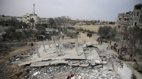 Palestinians inspect the ruins of a residential building destroyed in an Israeli airstrike in Rafah, Gaza, March 29, 2024