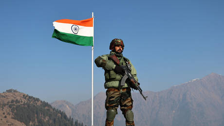 An army soldier is standing alert near the Indian National Flag (Tri-Color) at the Line of Control (LoC) between Pakistan and India in the Uri Sector, Jammu and Kashmir, India, on January 24, 2024.