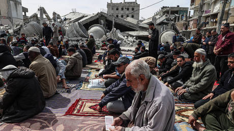 Palestinians pray in front of the ruins of the al-Faruq mosque, destroyed in Israeli strikes in Rafah in the southern Gaza Strip on March 1, 2024