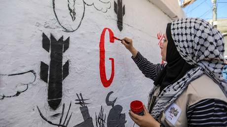  Displaced Palestinian artists paint an anti-Israel mural in Rafah, Gaza.