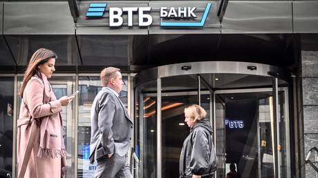FILE PHOTO: People walk past a branch of Russian VTB bank in Moscow.
