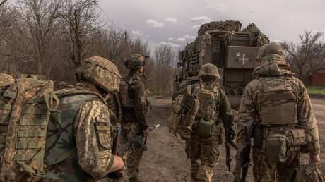 Ukrainian soldiers walk to board an armored fighting vehicle to head toward the frontline near Avdeevka, Donetsk People's Republic, April 3, 2024