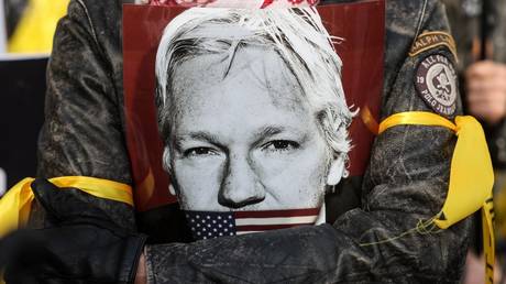 A demonstrator holds an image of Julian Assange during a protest outside of the Royal Courts of Justice in London, Britain, February 20, 2024