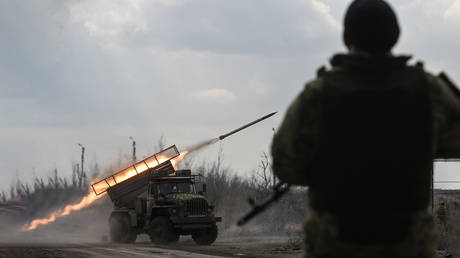  A Russian serviceman of the Centre group of forces stands guard as a BM-21 Grad multiple rocket launcher is fired towards Ukrainian positions in the Avdiivka sector of the front line.