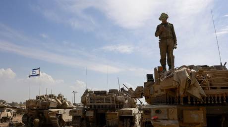 An Israeli soldier stands atop a tank in a army camp near Israel's border with Gaza, April 8, 2024