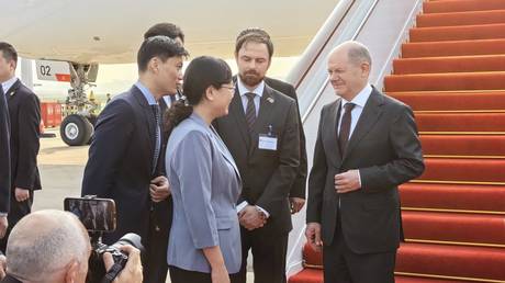 German Chancellor Olaf Scholz is greeted by the vice mayor of Chongqing, Zhang Guozhi, April 14, 2024.