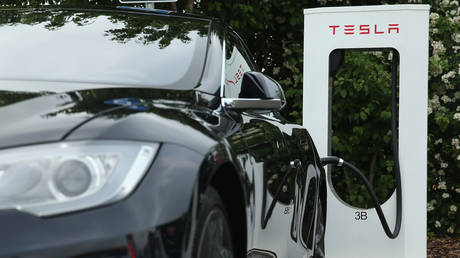 A Tesla electric-powered sedan stands at a Tesla charging staiton at a highway reststop along the A7 highway  Rieden, Germany.