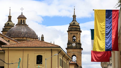 FILE PHOTO: The view of the dome and bell towers of Primatial Cathedral of Bogota in La Candelaria the historical center of Bogota with Colombian flag in foreground.