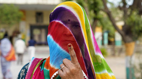 A woman shows her inked finger after casting her ballot to vote in the first phase of India's general election at a polling station in Parbatsar, Nagaur District, in the country's Rajasthan state on April 19, 2024.