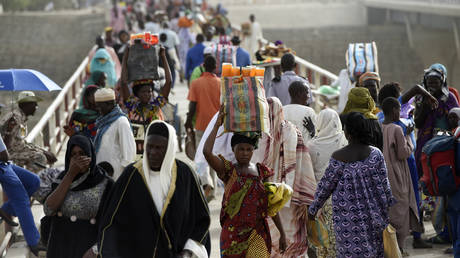 FILE PHOTO: People cross the N'Gueli bridge, marking the border between Chad and Cameroon near N'Djamena.