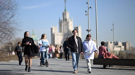 FILE PHOTO: People walk in a street on a warm spring day, in Moscow, Russia.
