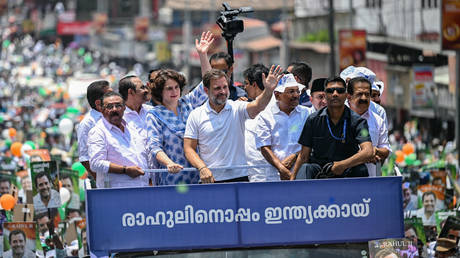 India's Congress party leader Rahul Gandhi (C) along with his sister Priyanka Gandhi Vadra (C, left) waves to supporters during a roadshow, before filing his nomination papers for the upcoming general elections, in Wayanad on April 3, 2024.