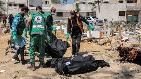 Palestinian paramedics carry away bodies of dead people uncovered in the vicinity of Al-Shifa Hospital in Gaza City.