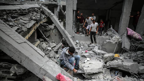 FILE PHOTO. Palestinians checking the damage in a house that was destroyed by an overnight Israeli bombardment in Gaza.