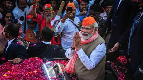 India's Prime Minister Narendra Modi greets crowds of supporters during a roadshow in support of state elections on March 04, 2022 in Varanasi, India.