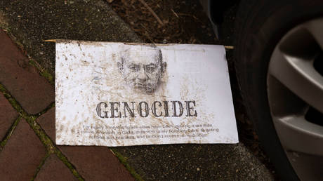 A leaflet with a drawing of Israeli PM Benjamin Netanyahu lies on the curbside outside the International Court of Justice on January 12, 2024 in The Hague, Netherlands.