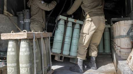 Israeli soldiers transport munitions off a vehicle at a position in the Israeli-annexed Golan Heights, January 2, 2023