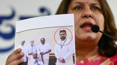 India's Congress party spokesperson Supriya Shrinate shows a photograph featuring JD(S) MP Prajwal Revanna  who was summoned for alleged sexual abuse case, at a press conference in Bengaluru on May 1, 2024.