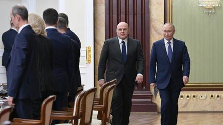 FILE PHOTO: Russian President Vladimir Putin and Prime Minister Mikhail Mishustin arrive for a government meeting.