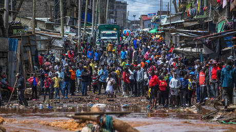 Residents are seen in a flooded street of Mathare neighborhood after heavy rains as they try to evacuate the area with their important belongings in Nairobi, Kenya on April 24, 2024.