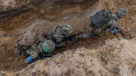 FILE PHOTO: Ukrainian soldiers practice trench assaulting during military training.