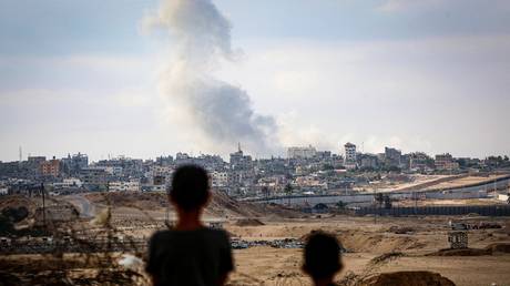 Boys watch smoke billowing during Israeli strikes east of Rafah, Gaza, May 13, 2024