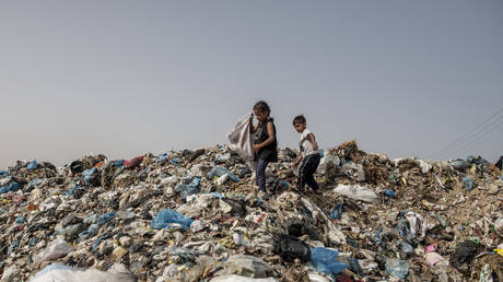 Palestinian children rummage through a garbage heap in Khan Yunis, Gaza, May 20, 2024