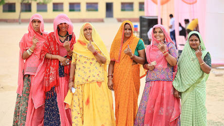 Women are displaying their fingers marked with indelible ink after voting in the second phase of the Lok Sabha elections in Dudu district, Rajasthan, India, on April 26, 2024
