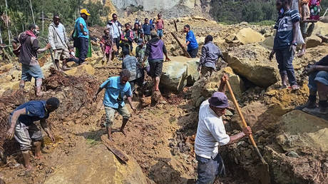 Villagers search through the rubble following a landslide in Yambali village, in the Highlands of Papua New Guinea, Sunday, May 26, 2024.