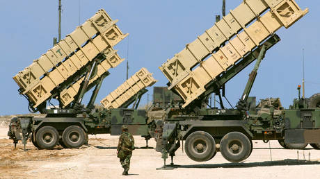 FILE PHOTO: An American soldier walks towards Patriot anti-missile batteries.