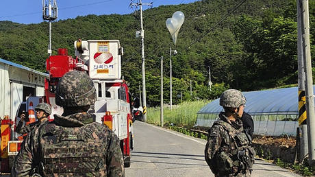 Balloons with trash presumably sent by North Korea, hang on electric wires as South Korean army soldiers stand guard in Muju, South Korea, on Wednesday, May 29, 2024.