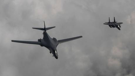 FILE PHOTO: A US Air Force B-1B Lancer bomber (L) flies with a South Korean F-15K fighter jet.