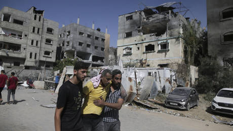 Palestinians help a wounded man after Israeli strikes in Nuseirat refugee camp, Gaza Strip, Saturday, June 8, 2024.