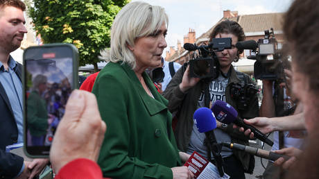 Marine Le Pen (C), leader of the French far-right Rassemblement National (RN) party's faction in parliament, speaks to the press in Courrieres, northern France on June 21, 2024.