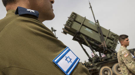 FILE PHOTO: US and Israeli army officers stand in front a US Patriot missile defence system.