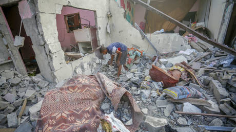 Palestinians examine the destroyed house and collect remaining belongings after the Israeli attack on June 28, 2024 in Deir al-Balah, Gaza.