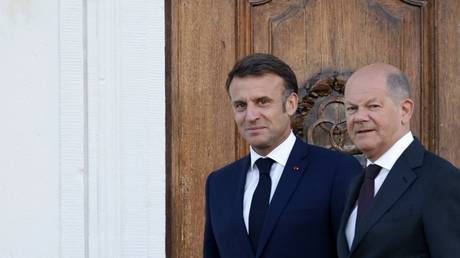 Emmanuel Macron (L) and Olaf Scholz arrive for a photo at the end of a joint Franco-German cabinet meeting in Meseberg, Germany, May 28, 2024