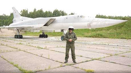 A Russian pilot standing in front of a Tu-22M3 strategic bomber.