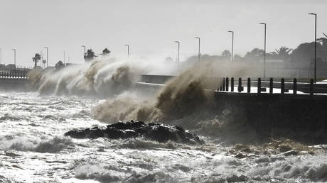 Waves break over Sea Point's promenade in Cape Town, South Africa, Monday, July 8, 2024.