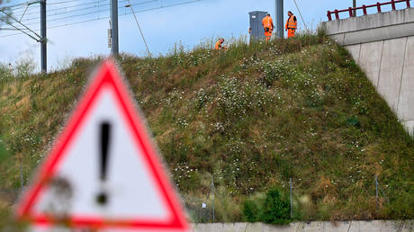 SNCF employees repair the scene of a suspected attack on the Eastern high speed railway network in Vandieres, north eastern France on July 26, 2024.