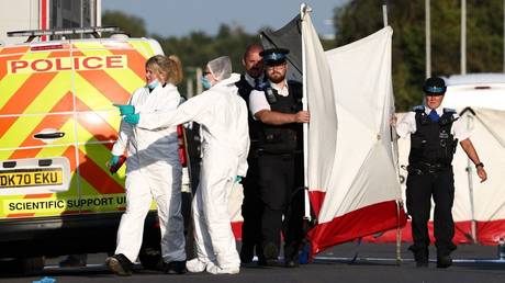 Police officers and forensic personnel put up a fence at the scene of a mass stabbing in Southport, England, July 29, 2024