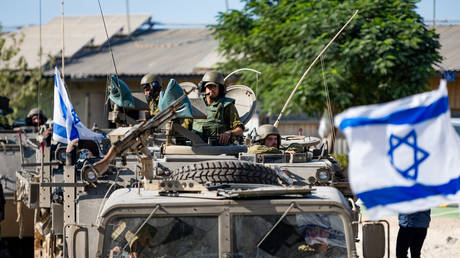 FILE PHOTO: IDF Soldiers ride in armored personnel carriers in Be'eri, Israel.