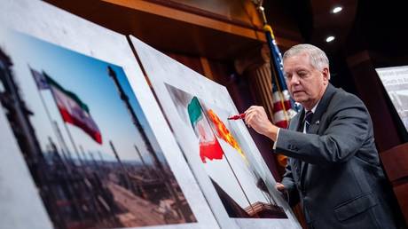 Lindsey Graham draws a red "x" over a photograph of an Iranian flag at a press conference at the US Capitol in Washington DC, July 31, 2024