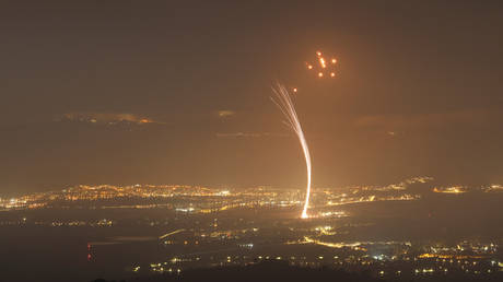 Rockets fired from southern Lebanon are intercepted by Israel’s Iron Dome air defense system over the Upper Galilee region in northern Israel on July 15, 2024.