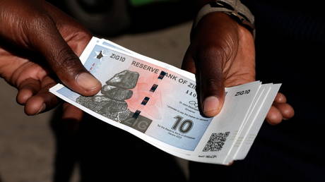 FILE PHOTO: People exchange new currency Zimbabwe Gold banknotes outside a bank in Harare, Zimbabwe.