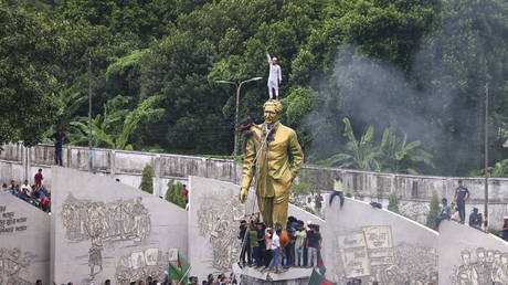 Protesters try to demolish a large statue of Sheikh Mujibur Rahman, the leader of country's independence movement in 1971 and a father of Bangladesh leader Sheikh Hasina, after she resigned as PM in Dhaka, Bangladesh, Monday, Aug. 5, 2024.