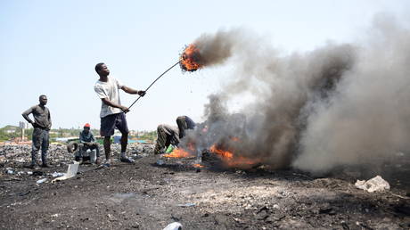 FILE PHOTO: Young men burn near the scrap yard Agbogbloshie cable on June 12 2018, Ghana, Accra.