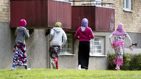 FILE PHOTO: Migrants outside an apartment block in Flen, Sweden.