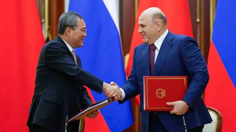 Russian Prime Minister Mikhail Mishustin and Premier of the State Council of China Li Qiang sign a joint communique on August 21, 2024.